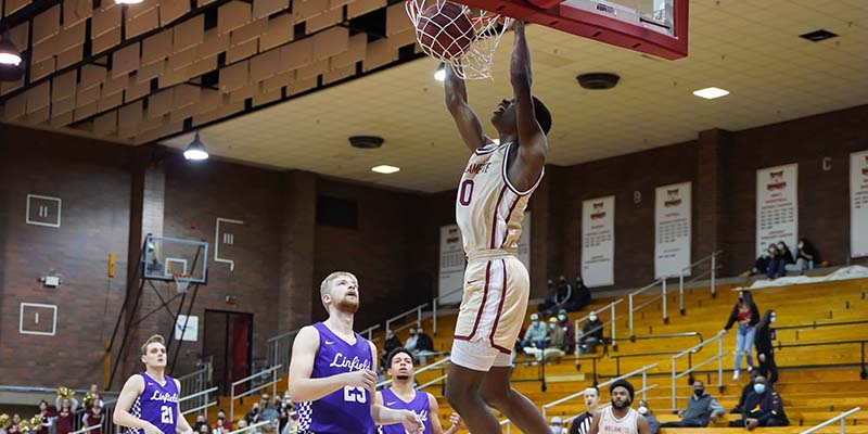 Cedric Coward dunks the basketball against Linfield.