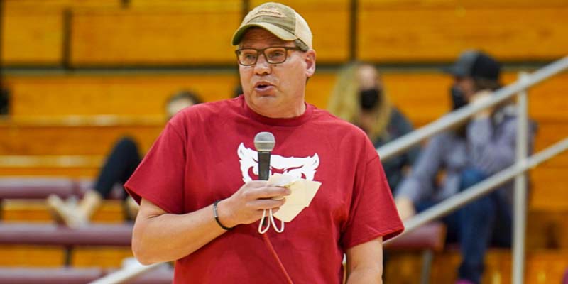 Todd Veenhuis speaks on a microphone at halftime about his wife's battle with a brain tumor.