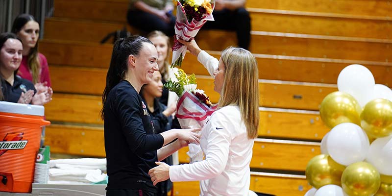 Sami Riggs, left, and Willamette Head Coach Peg Swadener, right, on Senior Night