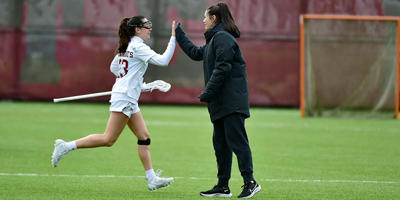 Lily Bachiochi and Willamette University Head Women's Lacrosse Coach Sarah Lautenbach meet with a high-five.
